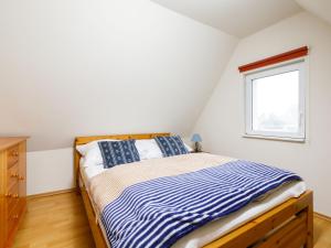 ein kleines Schlafzimmer mit einem Bett und einem Fenster in der Unterkunft Holiday Home Fischerbungalow by Interhome in Zempin