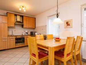 a kitchen with a wooden dining room table and chairs at Holiday Home Susi by Interhome in Ostseebad Koserow