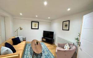 ミッチャムにあるLondon Mitcham Beautifully Presented Two Bedroom Apartmentのリビングルーム(ソファ、テーブル、テレビ付)