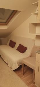 Cette chambre comprend un lit avec deux oreillers et une chaise. dans l'établissement Happy moment Niš, à Niš
