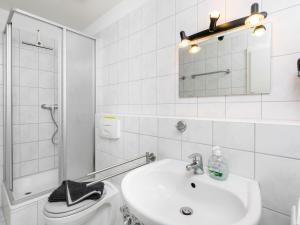 La salle de bains est pourvue d'un lavabo, de toilettes et d'un miroir. dans l'établissement Apartment Ostseeblick by Interhome, à Zinnowitz