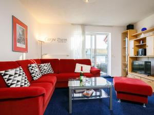 - un salon avec un canapé rouge et une table dans l'établissement Apartment Ostseeblick by Interhome, à Zinnowitz
