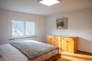 een slaapkamer met een bed en een raam bij Penthouse Visp - mit großer Dachterasse und Panoramablick in Visp