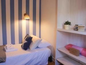 a bedroom with a bed with white sheets and pillows at Le Grand Bleu, 1 Court Cottages in Kingsbridge
