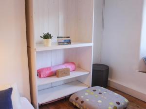 a room with white shelves and a pink pillow and a ottoman at Le Grand Bleu, 1 Court Cottages in Kingsbridge