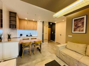 a kitchen and a living room with a table and a couch at Apartamenty Sun & Snow Polanka Niemena in Poznań