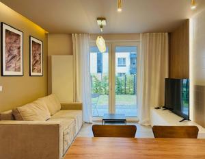a living room with a couch and a flat screen tv at Apartamenty Sun & Snow Polanka Niemena in Poznań