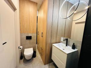 Łazienka z białą toaletą i umywalką w obiekcie Apartamenty Sun & Snow Polanka Niemena w Poznaniu