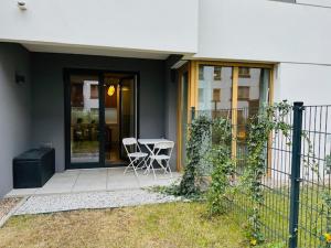 a house with a table and chairs on a porch at Apartamenty Sun & Snow Polanka Niemena in Poznań