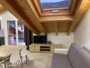 a living room with a couch and a tv and a table at La Fossola - vicino al Bernina Express in Tirano
