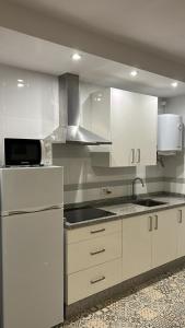 a kitchen with white cabinets and a white refrigerator at Apartamento Córdoba FAMORCAS in Almodóvar del Río