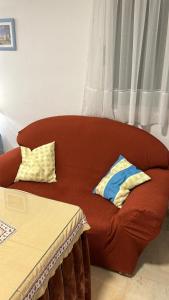 a red couch with two pillows sitting in a room at Apartamento Córdoba FAMORCAS in Almodóvar del Río
