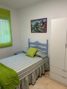 a bedroom with a bed with a green pillow on it at Apartamento Córdoba FAMORCAS in Almodóvar del Río