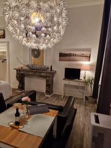 uma sala de estar com um lustre e uma mesa com cadeiras em Klooster Mariadal Maastricht em Maastricht