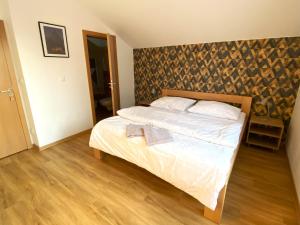 um quarto com uma cama e uma cabeceira em madeira em ANSEL Villa em Stará Lesná