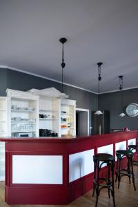 une cuisine avec un comptoir rouge et des tabourets dans l'établissement Alt-Berliner Eckkneipe - "Feuchte Ecke", à Berlin