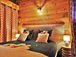 - une chambre avec un lit et un mur en bois dans l'établissement "Le Cabanon cendré" petit chalet cosy au coeur de Gérardmer, à Gérardmer