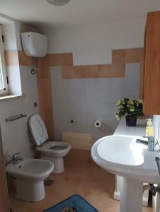 ein Badezimmer mit 2 WCs und einem Waschbecken in der Unterkunft Threehouses in Trecase