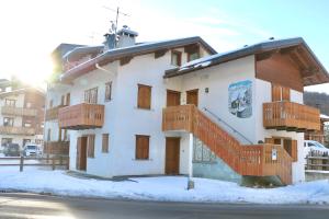 un edificio con balconi in legno sulla neve di Appartamenti Brunnlein a Livigno