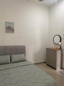 1 dormitorio con cama, tocador y espejo en Homestay Taman Melati Jerantut, en Jerantut