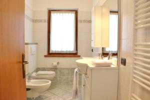 a white bathroom with a toilet and a sink at Appartamenti Brunnlein in Livigno