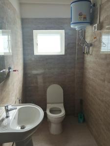 La salle de bains est pourvue de toilettes, d'un lavabo et d'une fenêtre. dans l'établissement PEACE HOMESTAY, à Takdāh