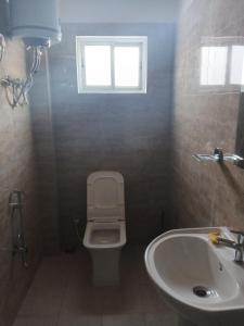 een badkamer met een toilet, een wastafel en een raam bij PEACE HOMESTAY in Takdāh