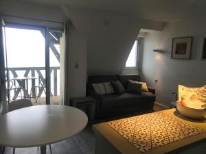 a living room with a couch and a table at Residence "Les Tamaris" in Trouville-sur-Mer