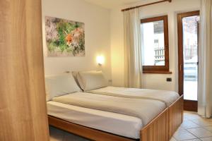 een bed in een kleine kamer met een raam bij Appartamenti Brunnlein in Livigno