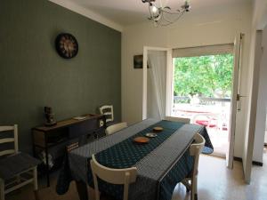 ein Esszimmer mit einem Tisch, Stühlen und einer Uhr in der Unterkunft Apartamento Llançà, 2 dormitorios, 4 personas - ES-228-72 in Llança