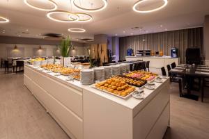 a buffet line with food on it in a restaurant at Best Western CTC Hotel Verona in San Giovanni Lupatoto