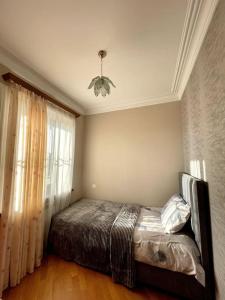 - une chambre avec un lit et un lustre dans l'établissement Sunny 2-Bedroom Flat in Yerevan., à Erevan