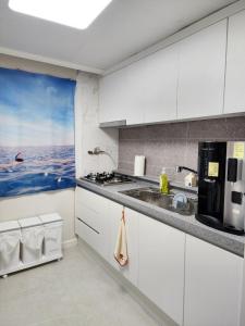 a kitchen with white cabinets and a sink at You Here,Stay - 5min to Hapjeong Station, 10mins to Hongdae in Seoul