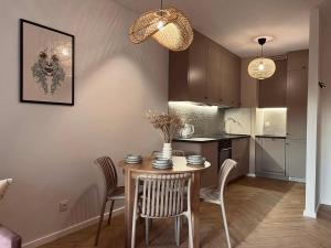 a kitchen and dining room with a table and chairs at Boho BOTANIC GARDEN APARTMENT centrum Wrocław in Wrocław