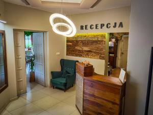 a lobby with a green chair and a sign that readsreciprocal sqor at Jaś i Małgosia in Poraj