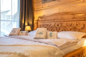 a bed with a wooden headboard and pillows on it at Centrum Park 2 Apartament 2 in Szklarska Poręba
