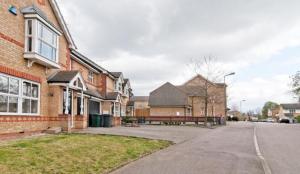 an empty street in front of a brick house at Ribblesdale Retreat in New Southgate