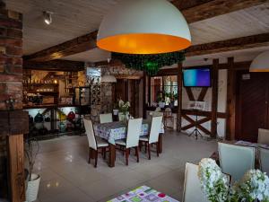 a dining room with a table and chairs and a television at Jaś i Małgosia in Poraj