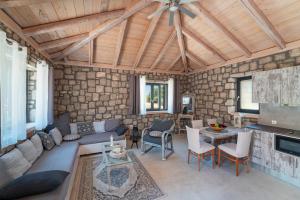 a large living room with a stone wall at AGROTOPIA Guesthouses in Theologos