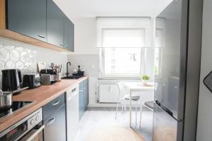 una cocina con armarios azules y una mesa. en HOMEFY BRIGHT AND COZY HOLIDAY APARTMENT, en Essen