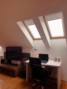 a room with a desk with a computer and two windows at KENT Apartments in Pristina