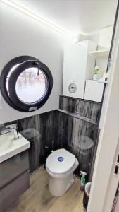 un piccolo bagno con servizi igienici e una finestra rotonda di Houseboat Water Boy apartament pływający dom na wodzie łódź a Uraz