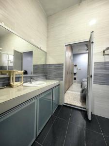 ein Bad mit einem Waschbecken und einem Spiegel in der Unterkunft Blossom seremban spacious comfy in Seremban