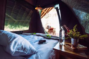 Maji Moto的住宿－瑪姬摩托車生態帳篷營地，帐篷内的一张床位,桌子上装有一瓶