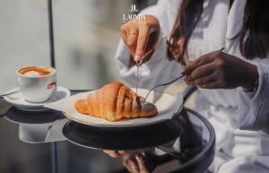 a person is holding a plate with a pastry at La Onda Hotel Durres in Durrës