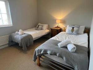 a room with two beds and a lamp in it at Nollaig Beachside Bliss - Pass the Keys in Rye