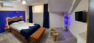 a bedroom with a blue bed and a tv at Kadıköy Linda Hotel in Istanbul