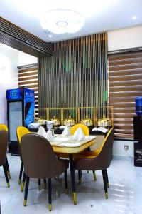 jadalnia ze stołem i żółtymi krzesłami w obiekcie Castle Estate APartments w mieście Abudża