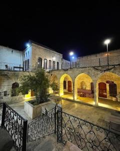 un edificio de piedra con patio por la noche en Muzepotamia Butik Otel en Sanlıurfa