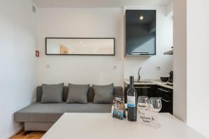 ein Wohnzimmer mit Sofa und Weingläsern in der Unterkunft Pratinhas in Porto